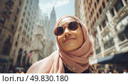 A woman wearing a pink scarf and sunglasses is smiling in front of a building. Стоковое AI-изображение, AI-художник Ярославский Максим / Фотобанк Лори
