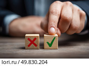 A hand is pointing at two wooden blocks with a red X. Стоковое AI-изображение, AI-художник Ярославский Максим / Фотобанк Лори