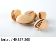 Handful of ripe pistachios on a white background. Стоковое фото, агентство Ingram Publishing / Фотобанк Лори
