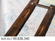 Vintage navigational instrument lying across a detailed nautical chart map. Стоковое фото, фотограф EugeneSergeev / Фотобанк Лори