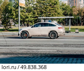 Fast moving white Mercedes GLE coupe SUV is driving on a city road. Premium car on street in motion. Overspeed in city concept. Редакционное фото, фотограф Константин Григорьев / Фотобанк Лори