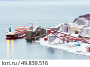 Industrial Container Cargo freight ship with working crane bridge in shipyard at Iron Ore Mine Factory Plant in Narvik Norway. Стоковое фото, агентство Ingram Publishing / Фотобанк Лори