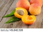 Apricots with leaves on the wooden table. Стоковое фото, агентство Ingram Publishing / Фотобанк Лори