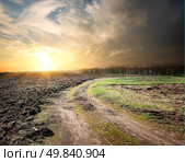 Country road through the plowed land at sunset. Стоковое фото, агентство Ingram Publishing / Фотобанк Лори