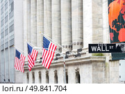 Wall street sign in New York with New York Stock Exchange background. Стоковое фото, агентство Ingram Publishing / Фотобанк Лори