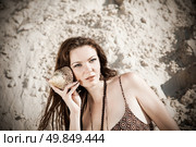 Attractive girl on the beach with shell. Стоковое фото, агентство Ingram Publishing / Фотобанк Лори