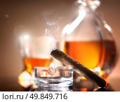 Cigar on ashtray on a background of whiskey. Стоковое фото, агентство Ingram Publishing / Фотобанк Лори