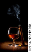 Wineglass of scotch and cigar on wooden table. Стоковое фото, агентство Ingram Publishing / Фотобанк Лори