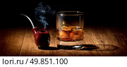 Tobacco pipe and glass of scotch on wooden table. Стоковое фото, агентство Ingram Publishing / Фотобанк Лори