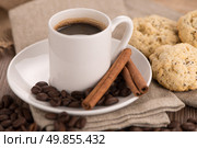 Coffee cup with burlap sack of roasted beans on rustic table. Стоковое фото, агентство Ingram Publishing / Фотобанк Лори