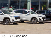 Russia, Samara. 23. 04 2025. Cars of the Chinese company Jetour are in the showroom for sale on a sunny summer day. Text in Russian: cars, used. Редакционное фото, фотограф Акиньшин Владимир / Фотобанк Лори