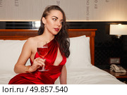 Crimson Allure Awaits Woman in Red Dress Holding a Glass of Wine. Стоковое фото, фотограф Aleksandr Golubev / Фотобанк Лори