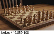 Wooden chess pieces arranged on a chessboard in a cozy setting. Стоковое AI-видео, аниматор KATERINA AI / Фотобанк Лори