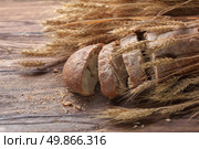 Bread and wheat on wooden table, shallow DOF, raw image. Стоковое фото, агентство Ingram Publishing / Фотобанк Лори