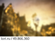 Defocused view of european city center houses against beautiful sunset, evening. Background with natural bokeh. Стоковое фото, агентство Ingram Publishing / Фотобанк Лори