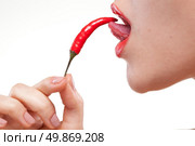 Young woman with chili pepper isolated on white. Стоковое фото, агентство Ingram Publishing / Фотобанк Лори