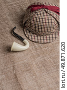 Deerstalker or Sherlock Hat and Tobacco pipe on Old Wooden table. Стоковое фото, агентство Ingram Publishing / Фотобанк Лори
