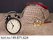 Deerstalker or Sherlock Hat and magnifying glass on Old Wooden table. Стоковое фото, агентство Ingram Publishing / Фотобанк Лори