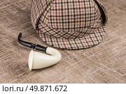 Deerstalker or Sherlock Hat and Tobacco pipe on Old Wooden table. Стоковое фото, агентство Ingram Publishing / Фотобанк Лори