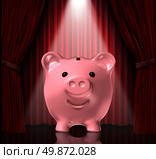 Focus on savings with a piggy bank in the spot light with elegant rich red velvet curtains as a background as a symbol of financial success and the importance of saving your money. Стоковое фото, агентство Ingram Publishing / Фотобанк Лори
