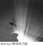 New beginnings and emerging opportunity business concept with an asphalt road that has a huge crack that is beaming with a glowing light as a symbol of hope and freedom. Стоковое фото, агентство Ingram Publishing / Фотобанк Лори