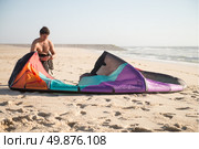 Kitesurfer prepating his equipment on a beautiful sunset at the beach. Стоковое фото, агентство Ingram Publishing / Фотобанк Лори