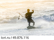 Kitesurfer in action on a beautiful background of spray during the sunset. Стоковое фото, агентство Ingram Publishing / Фотобанк Лори