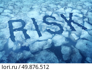 Risk and danger as a thin ice concept with the word imbedded in a cracked frozen lake warning any person to be very cautious as a business symbol of hazardous situation that is very dangerous. Стоковое фото, агентство Ingram Publishing / Фотобанк Лори