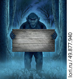 Monster holding a rustic blank old wood sign as a creepy halloween concept with a werewolf lurking as a bigfoot creature coming out of a dark scary background with a moon glow behind it as a horror symbol of a haunted woods animal. Стоковое фото, агентство Ingram Publishing / Фотобанк Лори