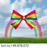 Gift of fortune and gifts from heaven concept with a colorful rainbow shaped as a fun and happy holiday ribbon and bow on a sky background as a symbol generosity in charity and donations for the joy of giving and receiving presents. Стоковое фото, агентство Ingram Publishing / Фотобанк Лори