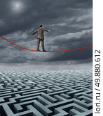 Finding New Solutions business challenges and a symbol for finding answers to financial problems with skilled leadership from as businessman walking on a tightrope over a maze searching for success. Стоковое фото, агентство Ingram Publishing / Фотобанк Лори
