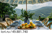 A table is set with blue and white dishes, adorned with vibrant yellow lemons creating a fresh and elegant tablescape. Стоковое AI-изображение, AI-художник Данила Большаков / Фотобанк Лори