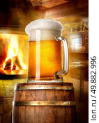 Mug of beer on wooden cask near fireplace in pub. Стоковое фото, агентство Ingram Publishing / Фотобанк Лори