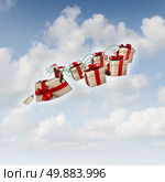 Christmas gift sled or santa sleigh concept as Santaclause riding a group of three dimensional presents with holiday silk ribbons as a traditional symbol of winter gift giving and seasonal festive icon for delivering joy to good boys and girls. Стоковое фото, агентство Ingram Publishing / Фотобанк Лори
