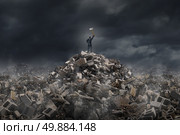 Destroy and demolish concept as a businessman  standing on a mountain of  building ruins holding a sledge hammer as a business or life metaphor for tearing down old industry to make room for a modern infrastructure. Стоковое фото, агентство Ingram Publishing / Фотобанк Лори