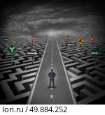Crisis solution concept as a businessman standing on a straight road through a maze or labyrinth with confusing direction road signs as a metaphor for finding the answer to a riddle as a clear strategy to overcome difficulties in business and the problems of life. Стоковое фото, агентство Ingram Publishing / Фотобанк Лори