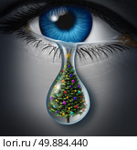 Holiday depression and winter season anxiety and emotional crisis concept as a human eyeball crying a tear with a christmas tree inside as a metaphor for seasonal sadness. Стоковое фото, агентство Ingram Publishing / Фотобанк Лори