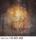 Demon face and scary monster concept as a screaming cruel zombie or vampire appearing from the dark shadows as a horror and halloween concept. Стоковое фото, агентство Ingram Publishing / Фотобанк Лори
