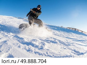 Snowboard freerider in the mountains against sun shine in blue sky. Стоковое фото, агентство Ingram Publishing / Фотобанк Лори