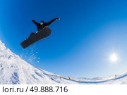 Snowboarder executing a radical jump against blue sky. Стоковое фото, агентство Ingram Publishing / Фотобанк Лори