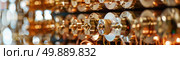 A close-up view showing a bunch of shiny gold coins stacked together, reflecting light and creating a gleaming display. Стоковое AI-изображение, AI-художник Данила Большаков / Фотобанк Лори