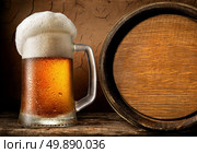 Frothy beer and wooden barrel in clay cellar. Стоковое фото, агентство Ingram Publishing / Фотобанк Лори