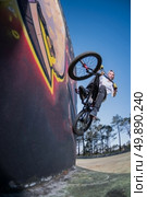 Bmx Bike Stunt Wall Ride on a skatepark. Стоковое фото, агентство Ingram Publishing / Фотобанк Лори
