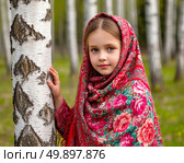 A little Russian beauty in a bright Pavlovo Posad shawl against the backdrop of birches. Стоковое AI-изображение, AI-художник Сергей Елизарьев / Фотобанк Лори