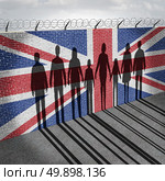 Britain immigration refugee crisis concept as people on a border wall with a British flag as a social issue on refugees or UK illegal immigrants with the shadow of a group of migrants with 3D illustration elements. Стоковое фото, агентство Ingram Publishing / Фотобанк Лори