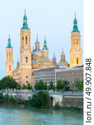 Our Lady of the Pillar Basilica with Ebro River at dusk Zaragoza, Spain. Стоковое фото, агентство Ingram Publishing / Фотобанк Лори