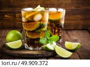Cuba Libre cocktail with cola, lime and ice in glass, cold longdrink. Стоковое фото, агентство Ingram Publishing / Фотобанк Лори