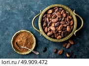 Cocoa beans and powder on dark background, top view, copy space, flat lay. Стоковое фото, агентство Ingram Publishing / Фотобанк Лори