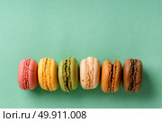 Sweet macarons in line on a turquoise background. Стоковое фото, агентство Ingram Publishing / Фотобанк Лори