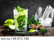 Refreshing mint cocktail mojito with rum and lime, cold drink or beverage with ice on black background. Стоковое фото, агентство Ingram Publishing / Фотобанк Лори